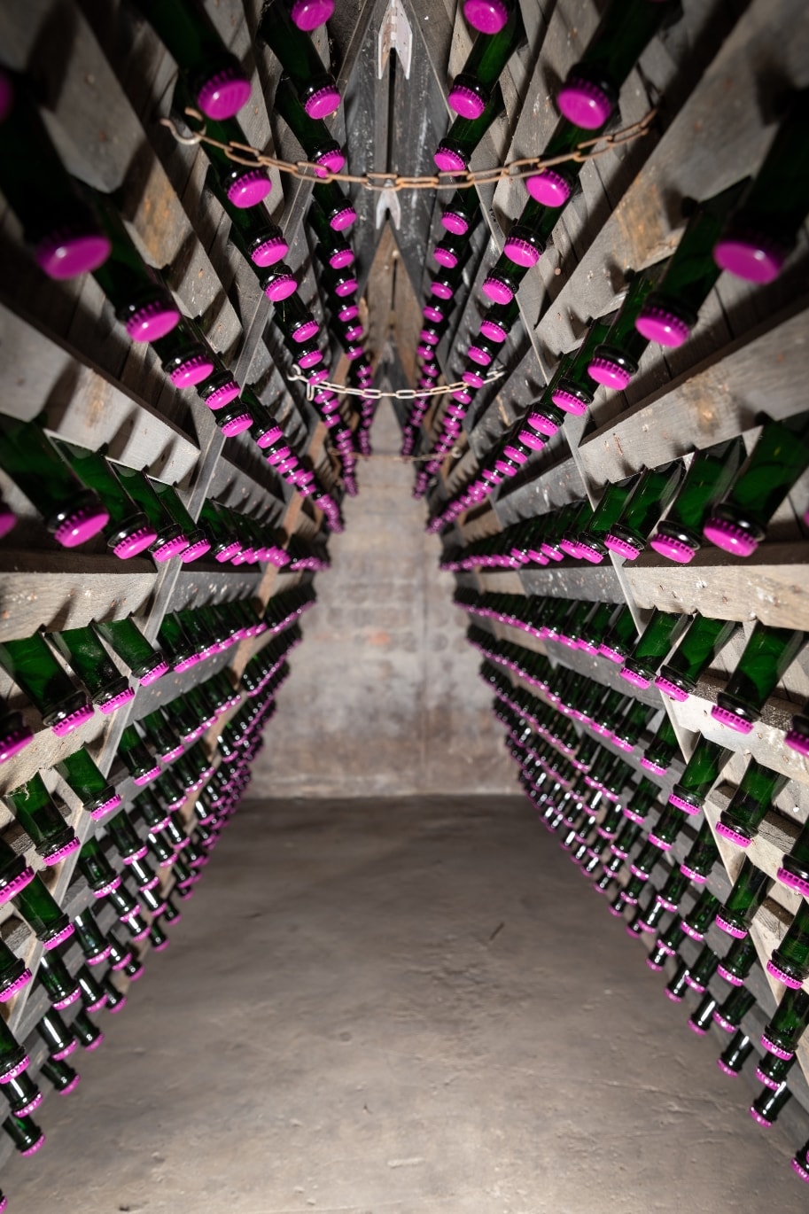 Bouteilles sur pupitres en cave de vieillissement