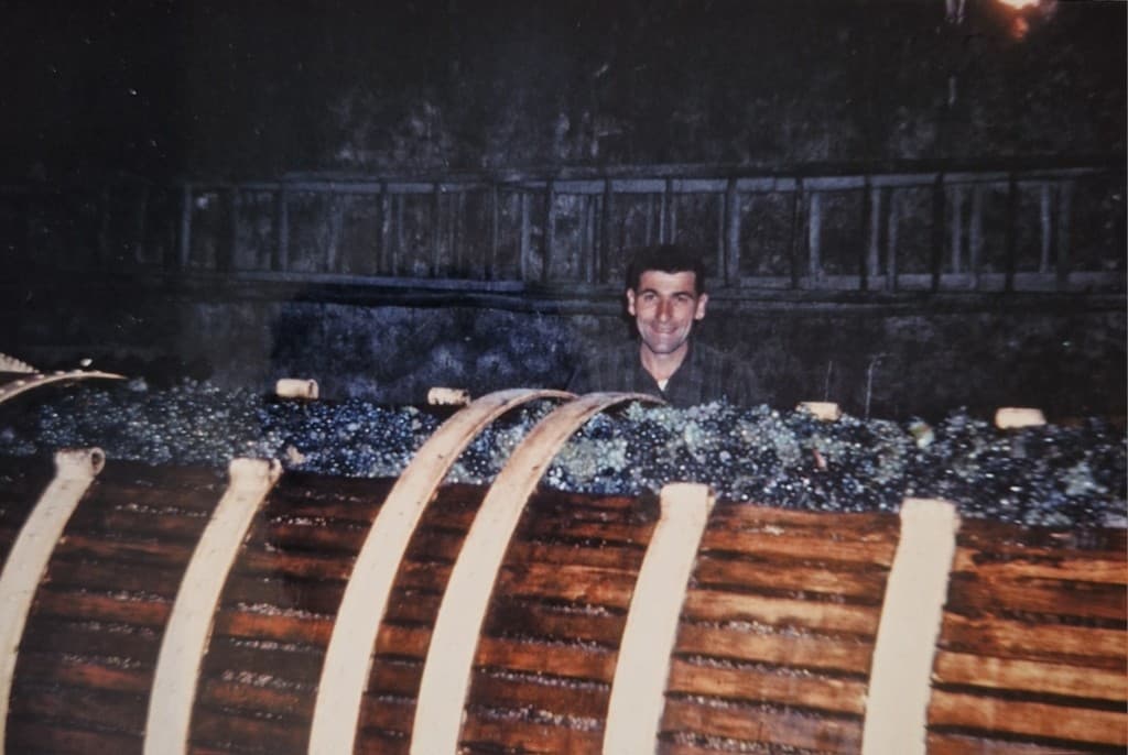 Bernard Jobin derrière une cuve de vendanges en cave