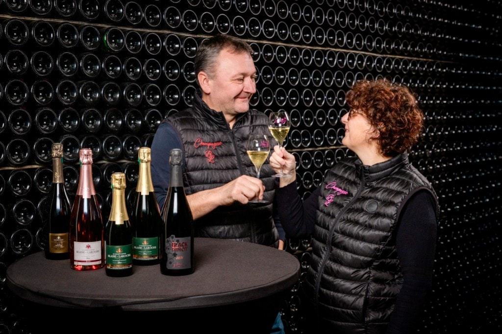 Michael et Fanny trinquant dans leur cave entourés de leurs cuvées