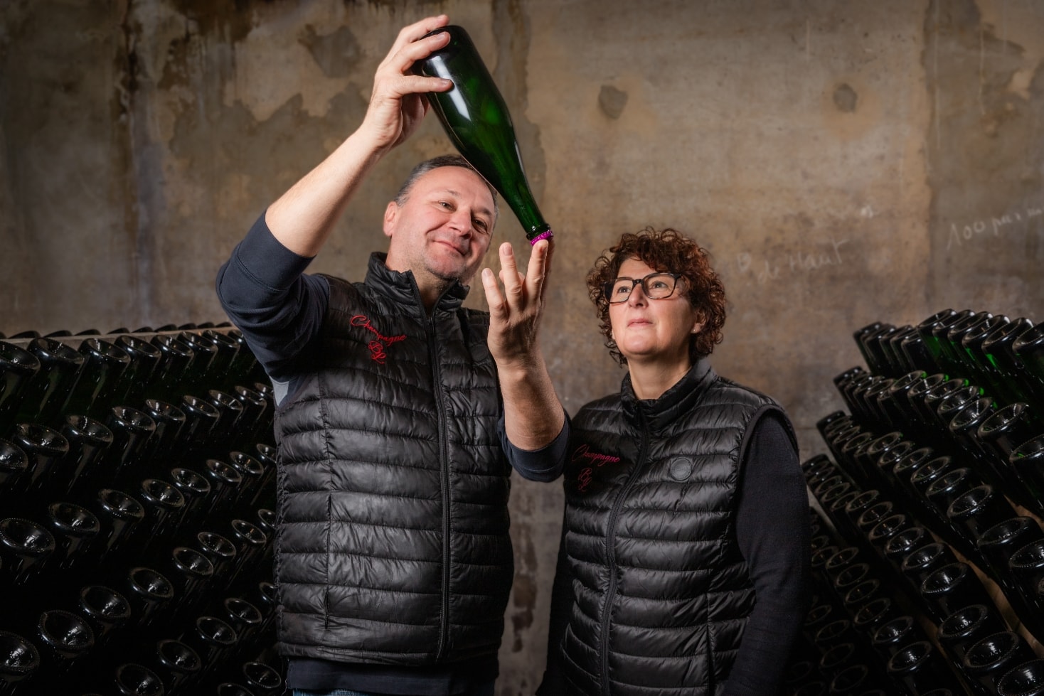 Michael et Fanny examinant une bouteille en cave